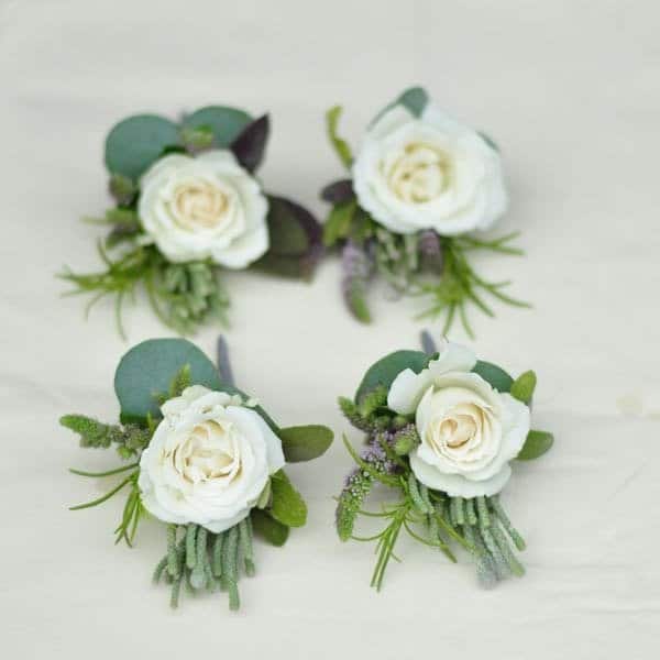 white rose buttonholes with eucalytpus, scented mint and rosemary. These are pefect for men to wear to a summer wedding. For more wedding flower ideas follow us on Pinterest www.pinterest.com/green_parlour