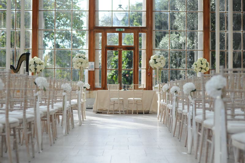 white hydrangeas lining the aisle at a wedding in the Nash Conservatory at Kew Gardens