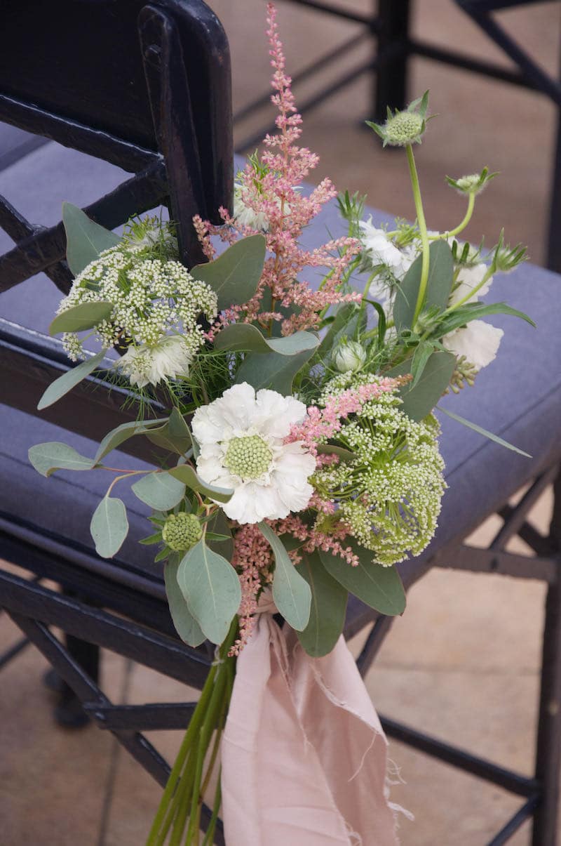 Country style wedding flower bunches lining the ailse at The Dairy at Waddeston Manor