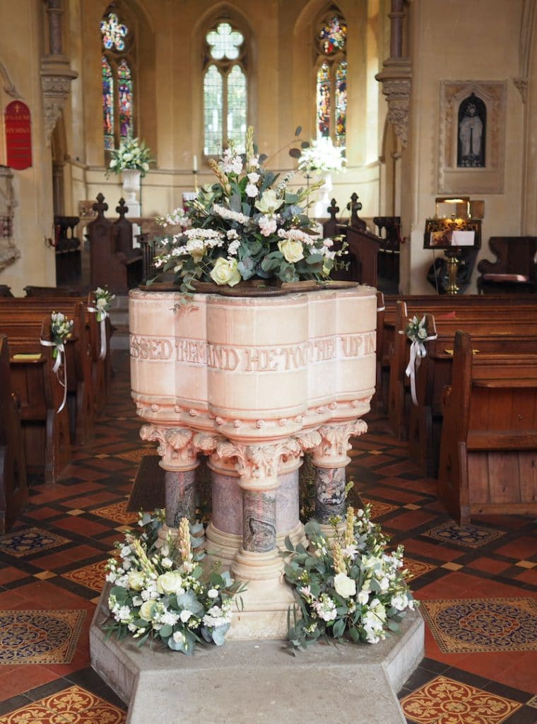 Large traditional flower urns and font flowers at St Katharines Church Savernake Forest