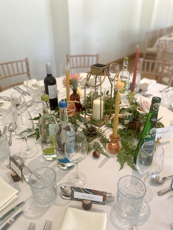 The image shows a selection of small bottles filled with flowers at Dorney Court in Berkshire