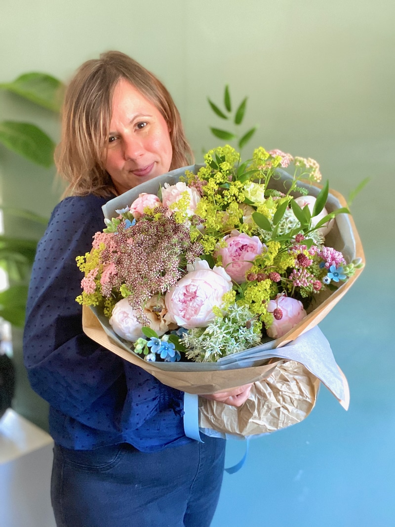 Florist creating a small arrangement on a workbench, symbolising starting small in business