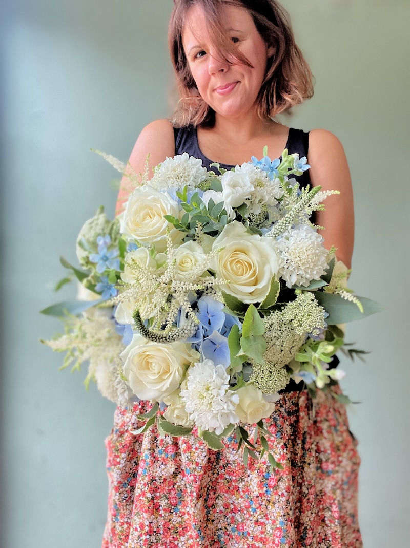 Florist arranging flowers in a studio workspace to illustrate starting a floristry business.