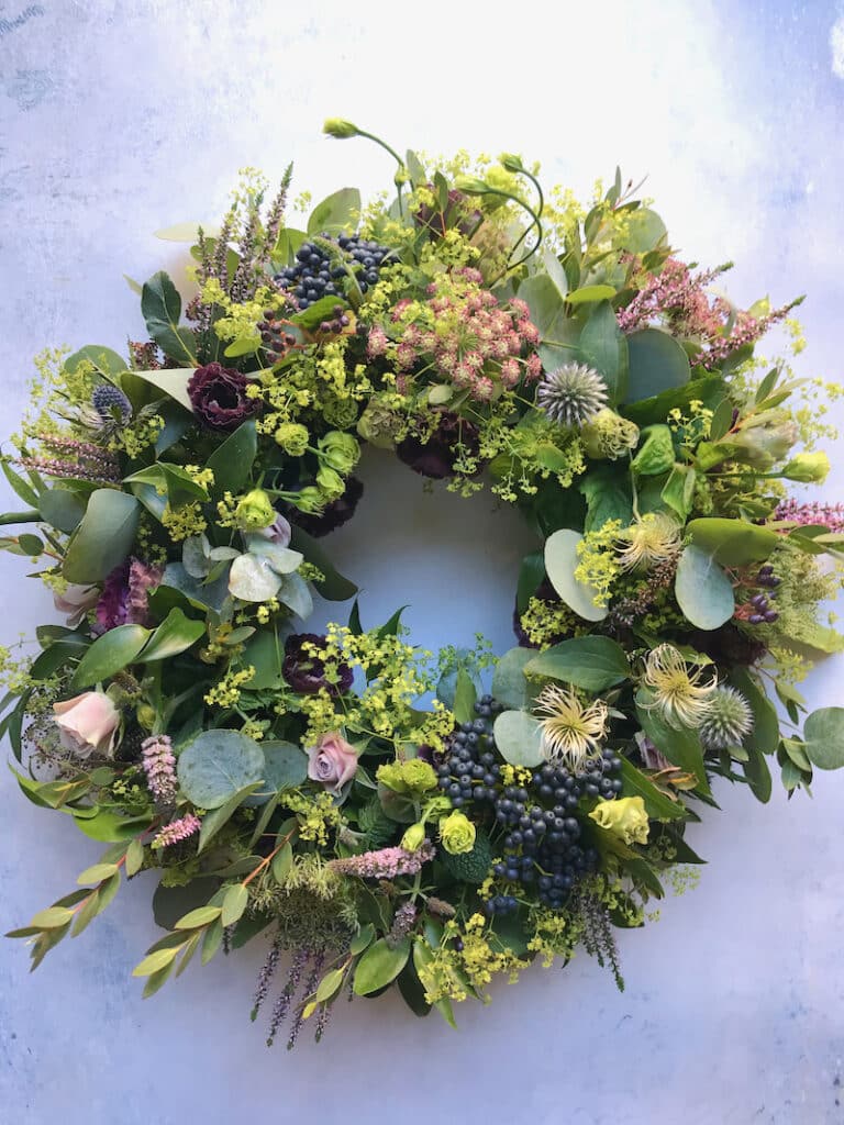 Romantic autumn wreath with soft-toned flowers, foliage, and seasonal berries