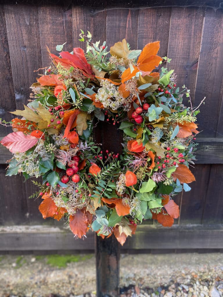 Autumn wreath with golden leaves, textured foliage, and seasonal accents