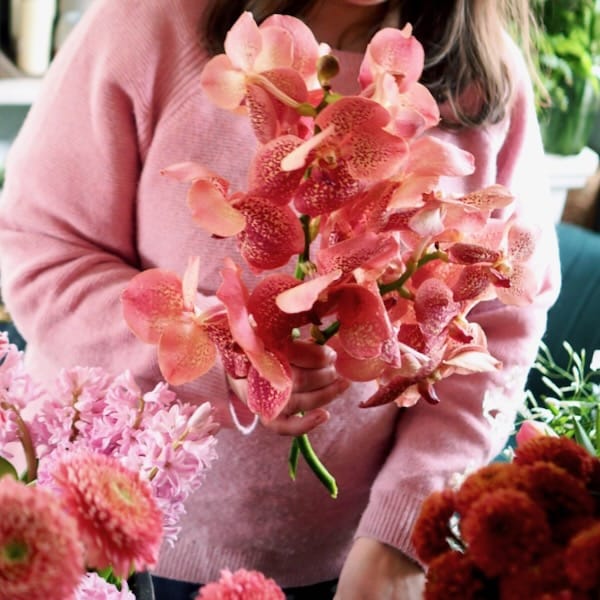 Beginner floristry workshop showing people learning simple flower arranging techniques
